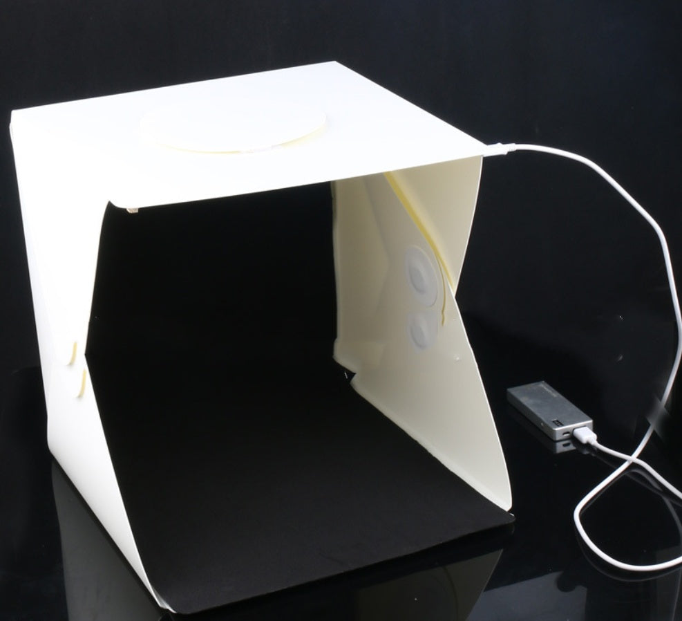 Small light box with a power adapter on a black background