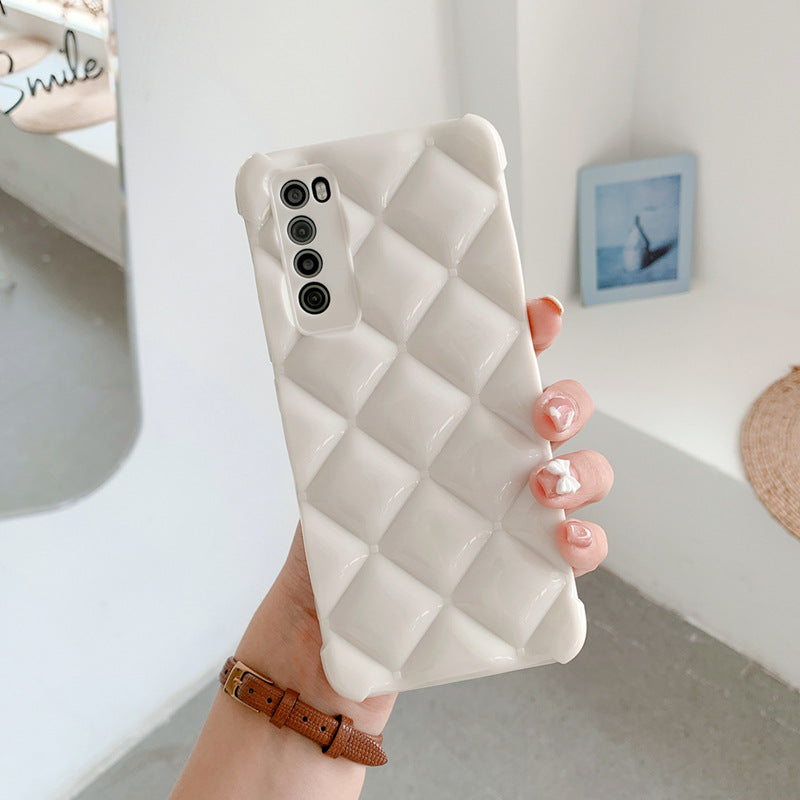 Person holding a phone with a diamond pattern case in a minimal indoor setting
