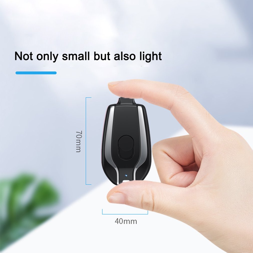 Small black device held in a hand with measurements indicated, on a light background.