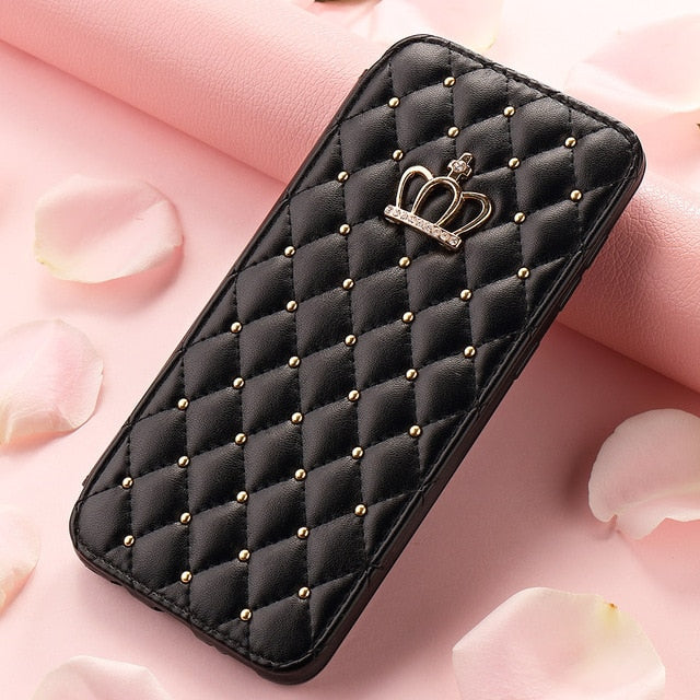 Black quilted phone case with a crown charm on a pink floral background