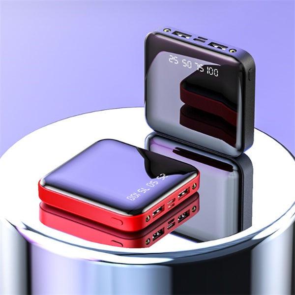 Two portable power banks, one red and one black with digital display, on a reflective surface.