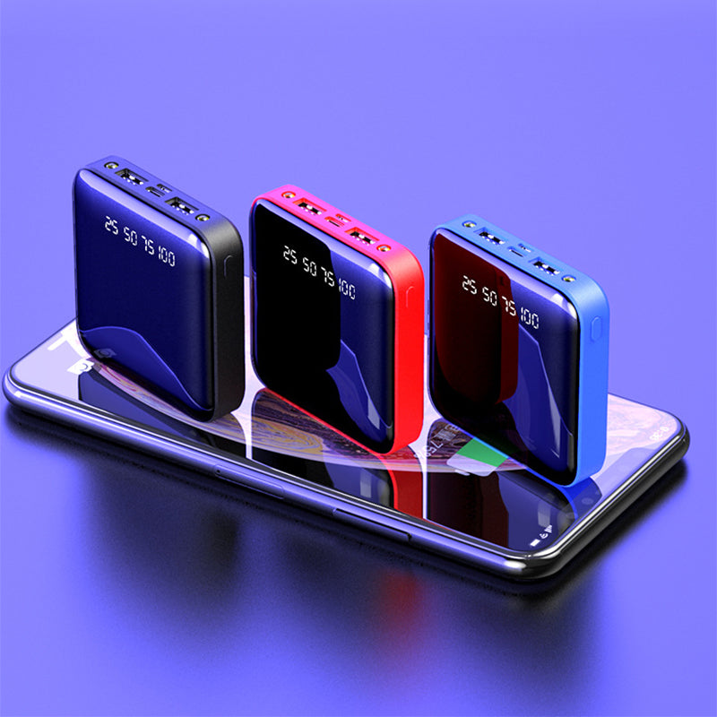 Three portable power banks in blue, red, and black on a reflective surface with a purple gradient background.