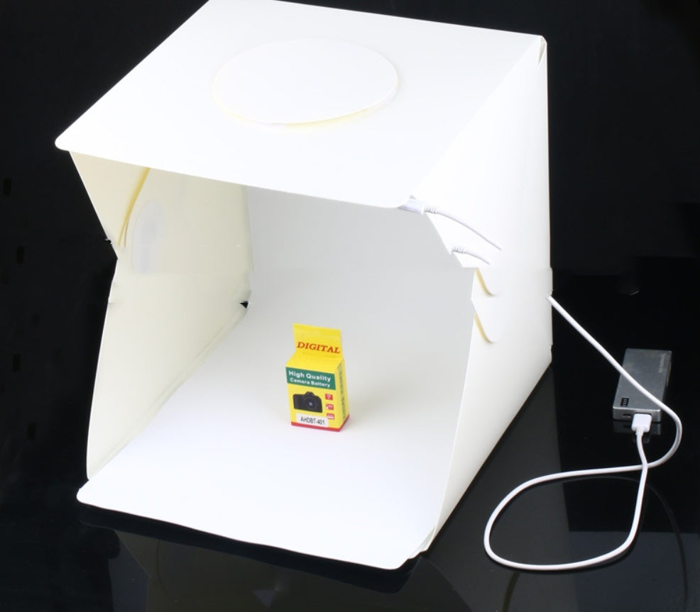 Small box with 'Digital' branding inside a white photo studio light tent on a black surface.