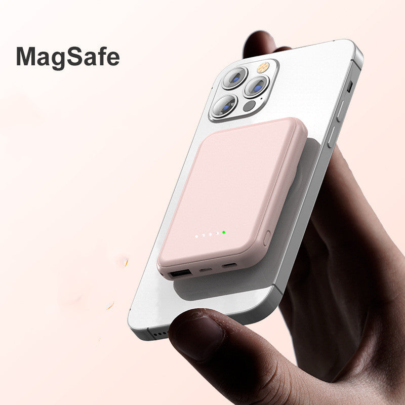 Smartphone with a MagSafe accessory held by a hand on a light pink background