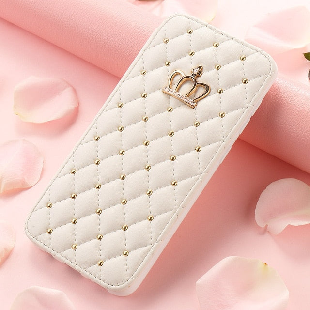 White quilted phone case with gold accents and a crown emblem on a pink floral background