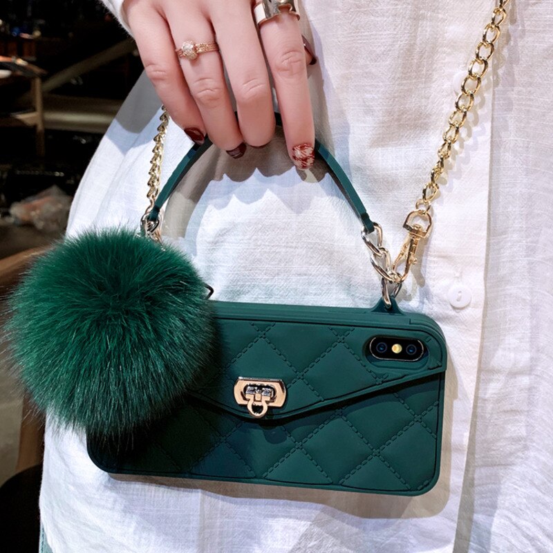Green quilted phone case with a fur pom-pom held by a person wearing a white shirt.
