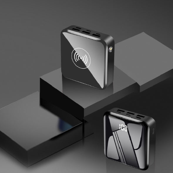 Two black electronic devices on a reflective surface with a dark background