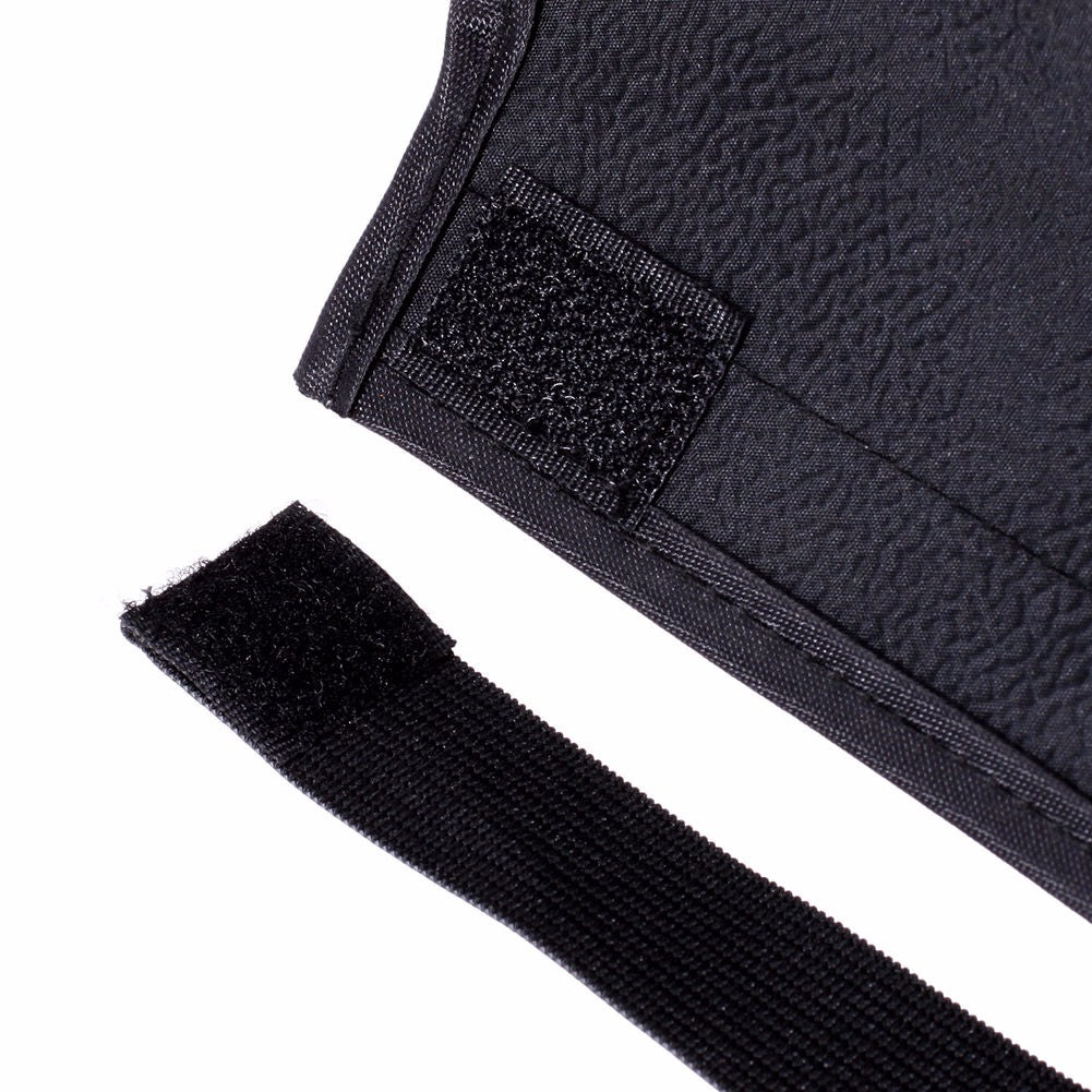 Close-up of a textured black fabric with a black label and a strip of black tape on a white background.