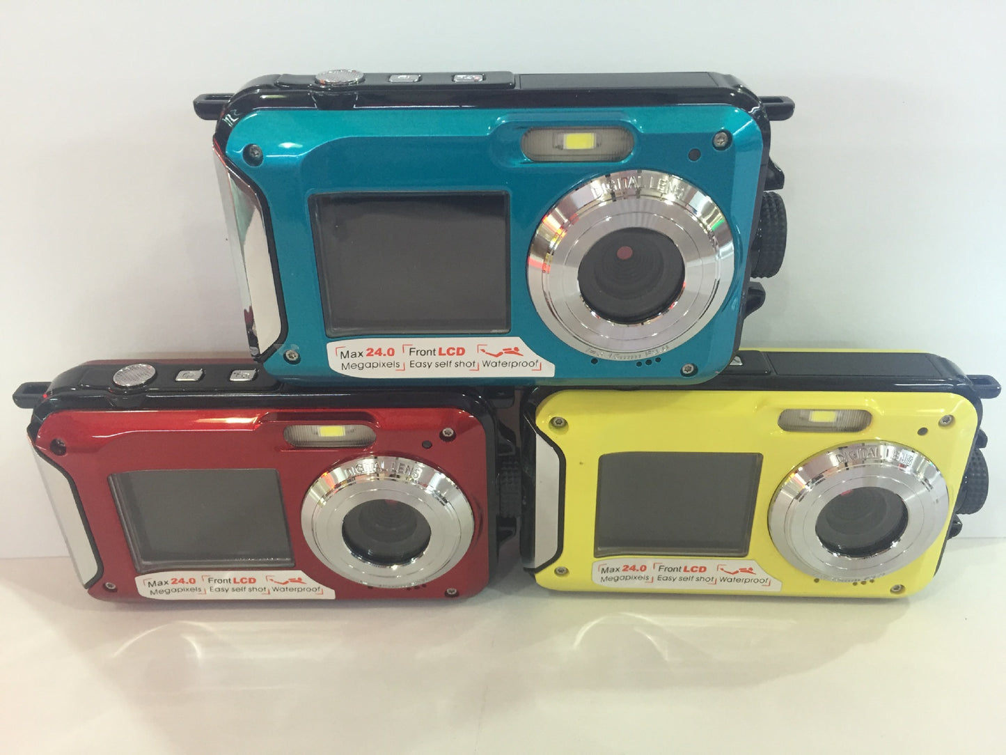 Three colorful digital cameras stacked on a white background