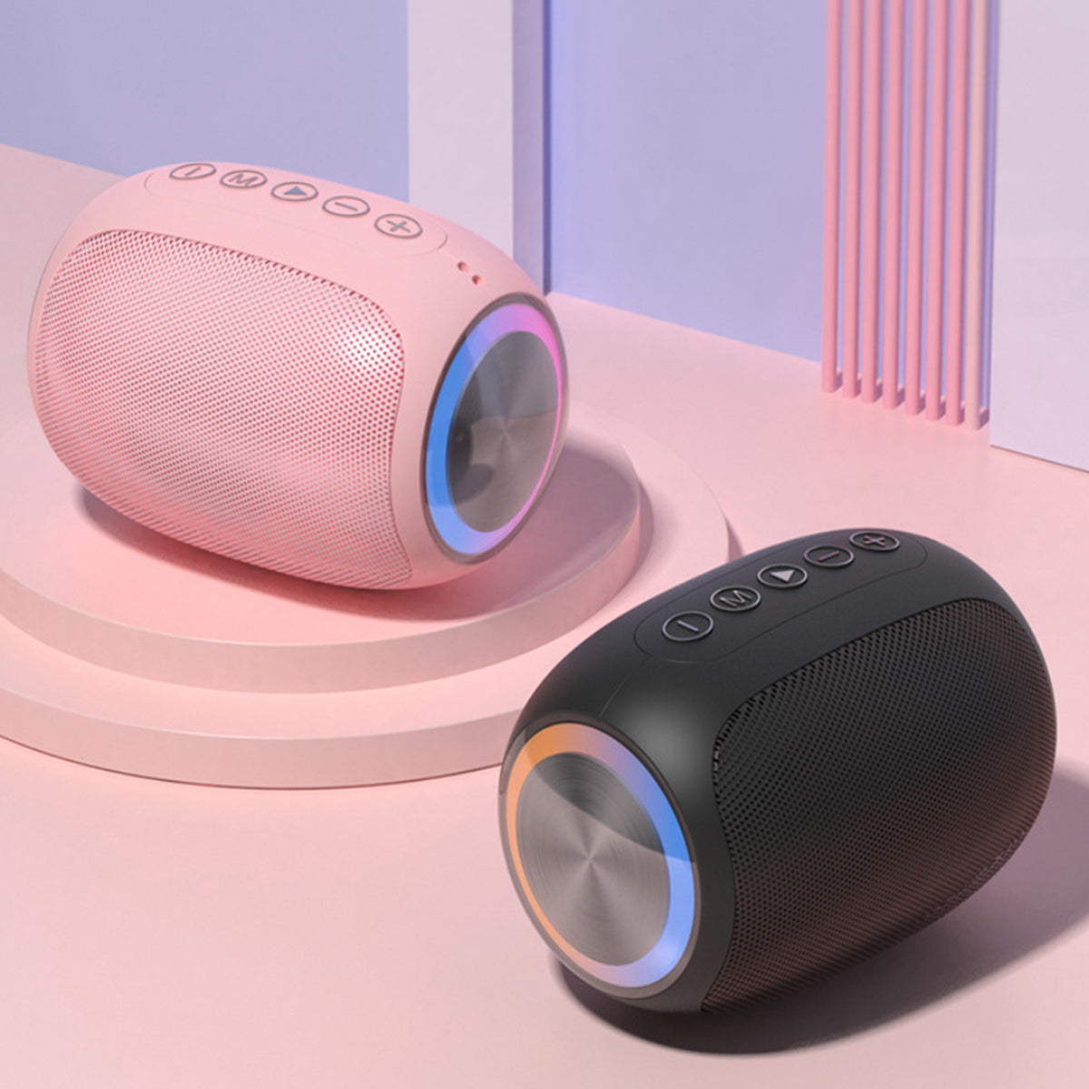 Two wireless speakers, one pink and one black, on a pastel pink platform with a light blue background.  best noise cancelling headphones under $100. Raee Industries 
