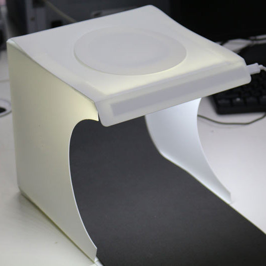 White electronic device on a desk with keyboard in the background