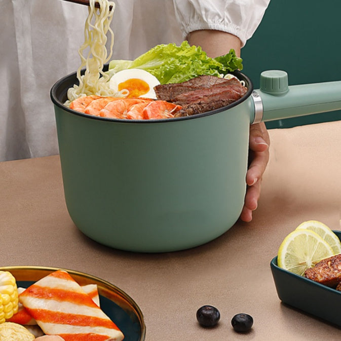 Person holding a green portable pot with food on a table