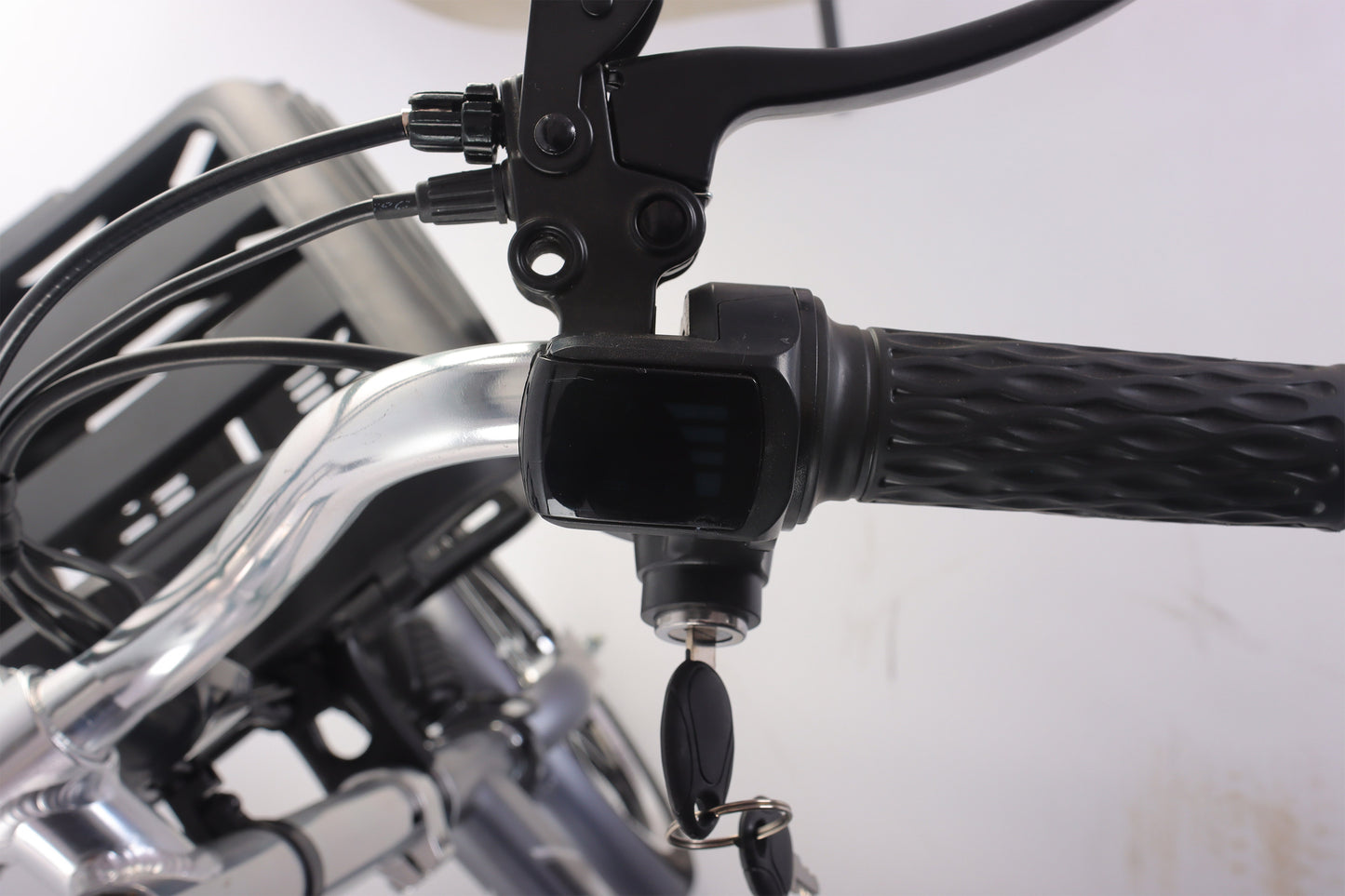 Close-up of a bicycle handlebar with a brake lever and throttle control on a blurred background