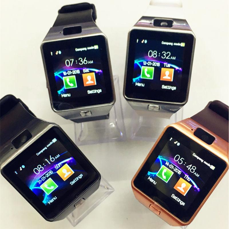 Four smartwatches displayed on a white surface with clear stands.
